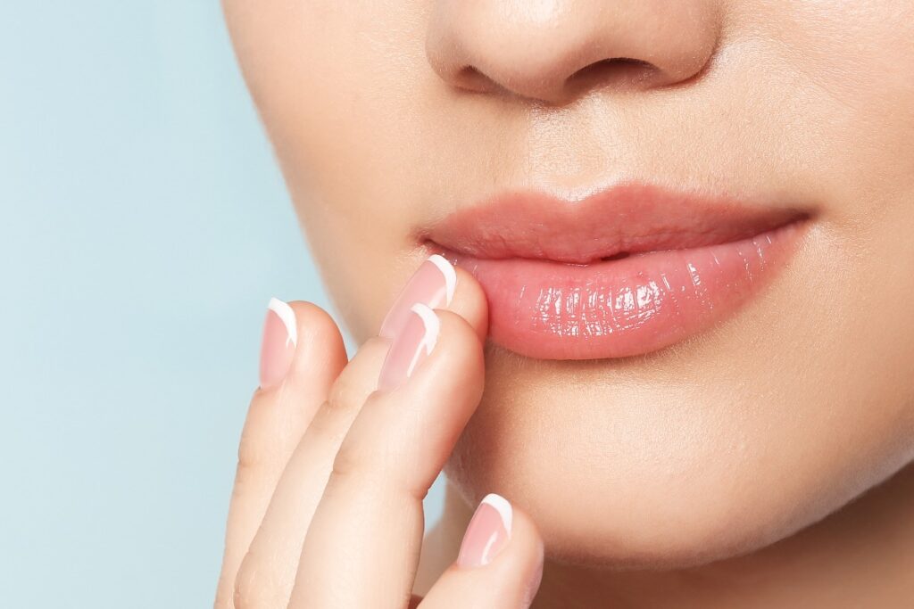 Young woman with sexy lips on color background, closeup